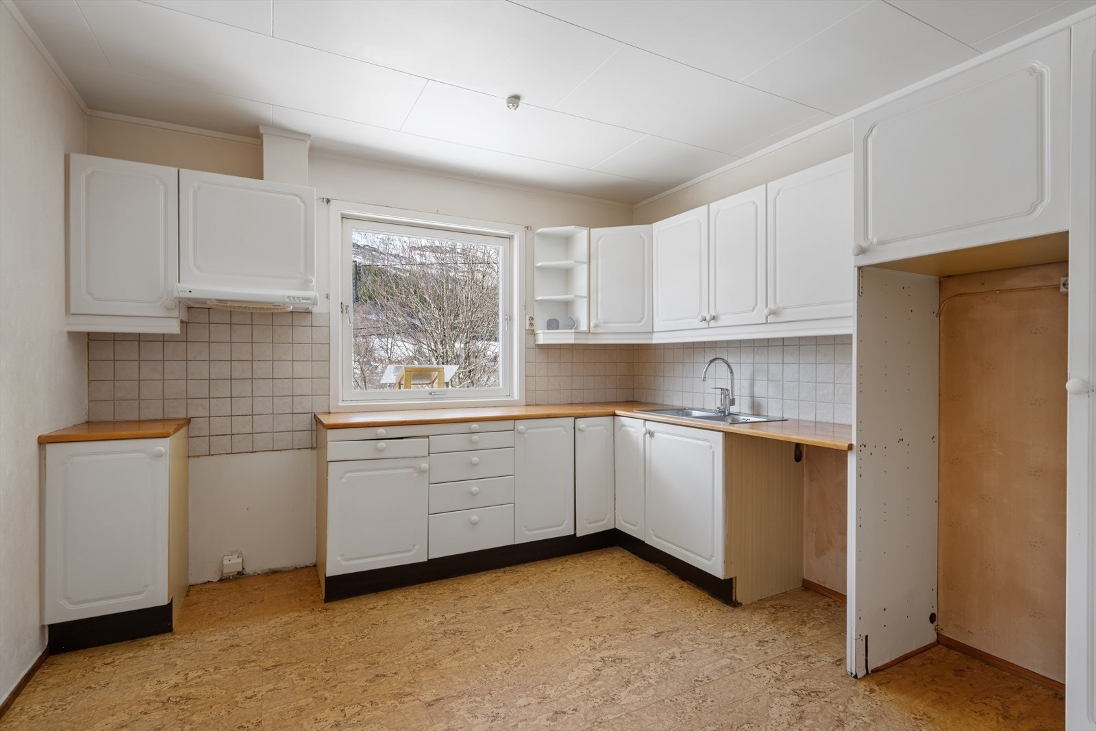 Kjøkkenet har en innredning med profilerte fronter og heltre benkeplate. Galleribilde