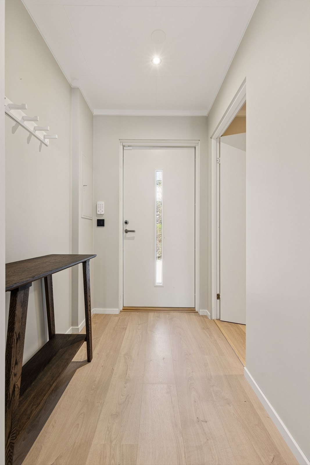 Velkommen inn i en lys og tiltalende bolig med pen standard, med spennende planløsning og gode oppholdsarealer. Entréen fremstår lys og innbydende med lyse vegger og lyst laminatgulv, som er gjennomgående i boligen. Galleribilde