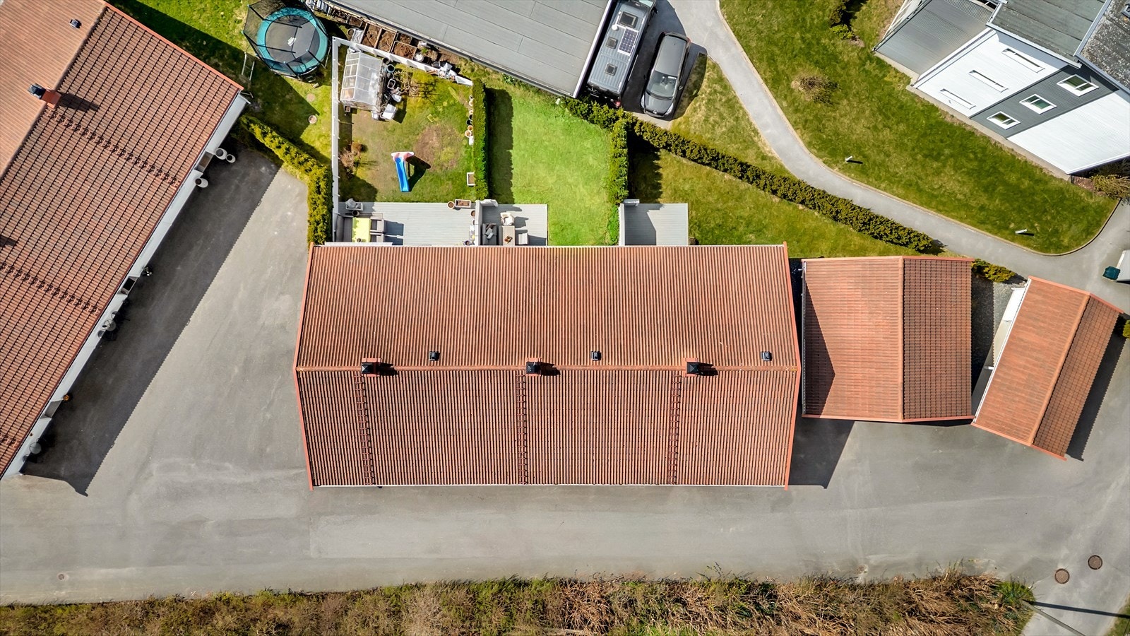 Eiendommen sett fra luften, med privat hage og carport. Galleribilde