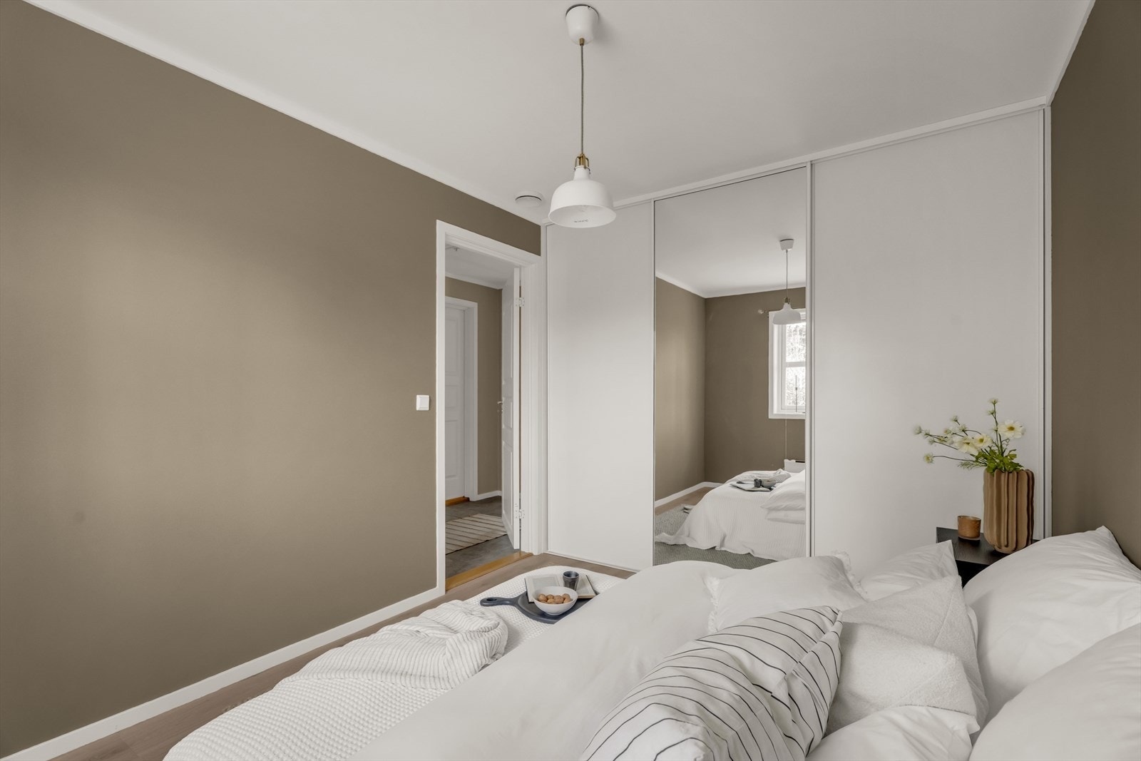 En stor skyvedørsgarderobe med speilfronter gir rikelig med oppbevaringsplass og en god romfølelse. Galleribilde