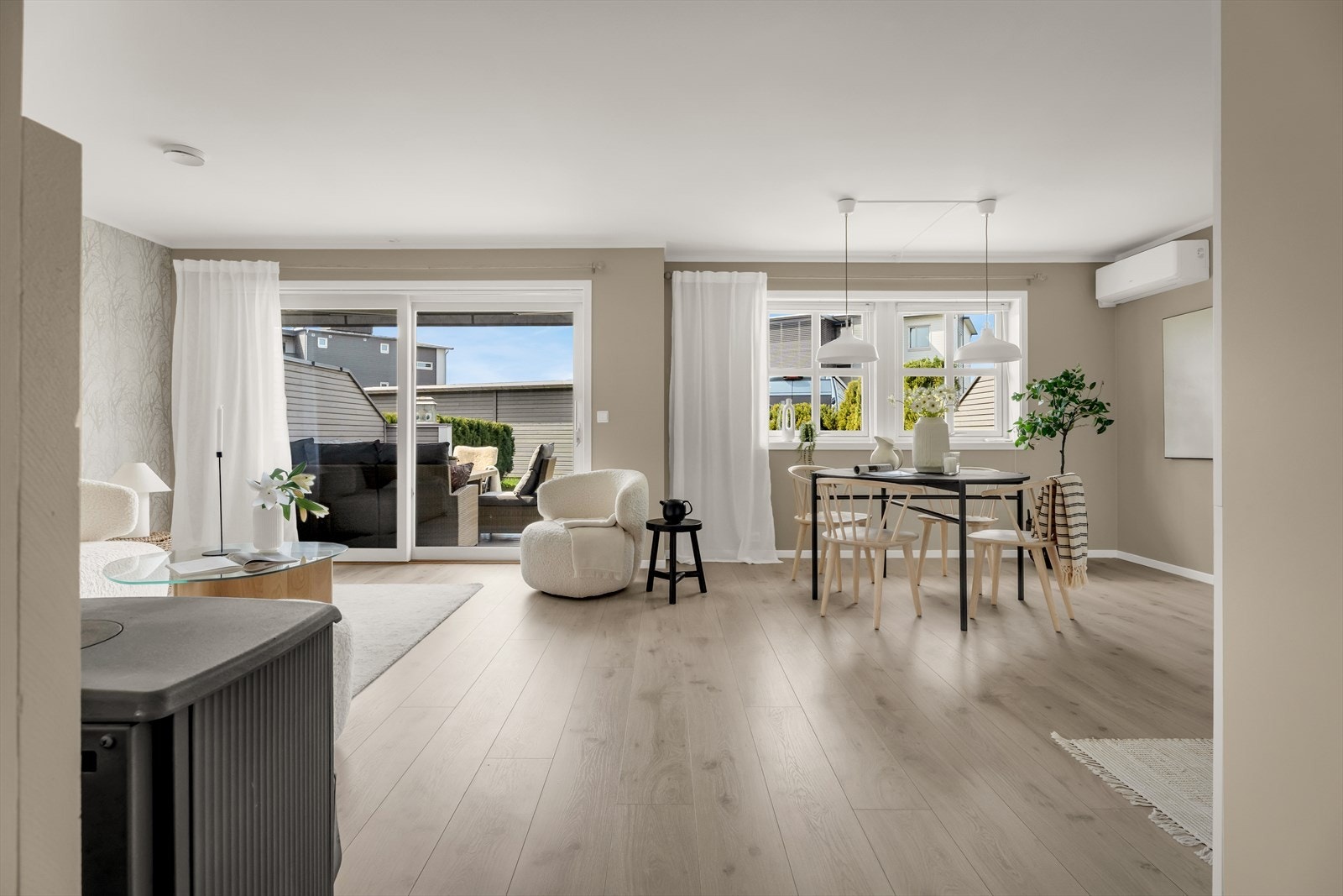 Stuen har god plass til både sofagruppe og spisebord, og en hev-skyvedør i glass gir direkte utgang til terrassen. Galleribilde
