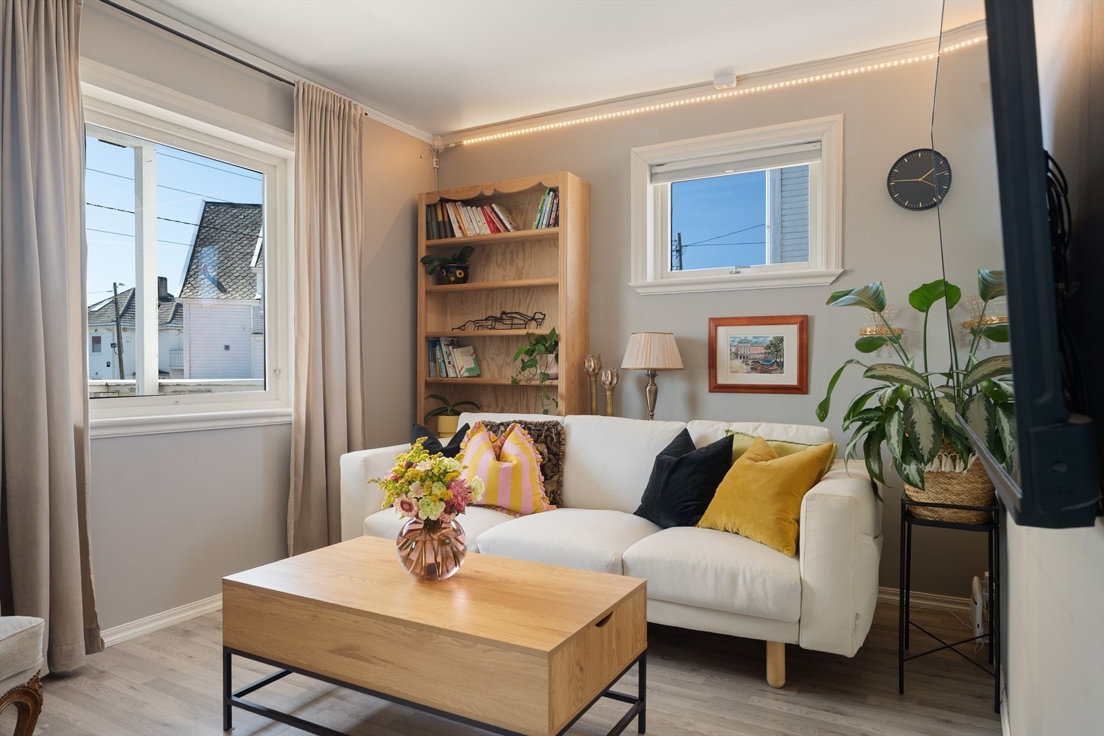 Pent innredet stue med moderne laminatgulv og malte vegger. Galleribilde