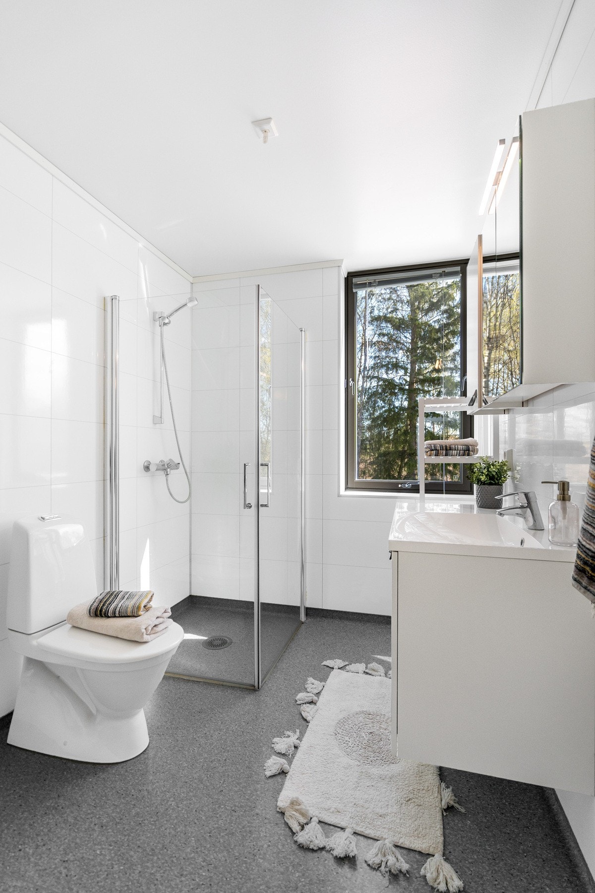 Badet er innredet med dusjhjørne, toalett, servantinnredning og opplegg for vaskemaskin. Galleribilde