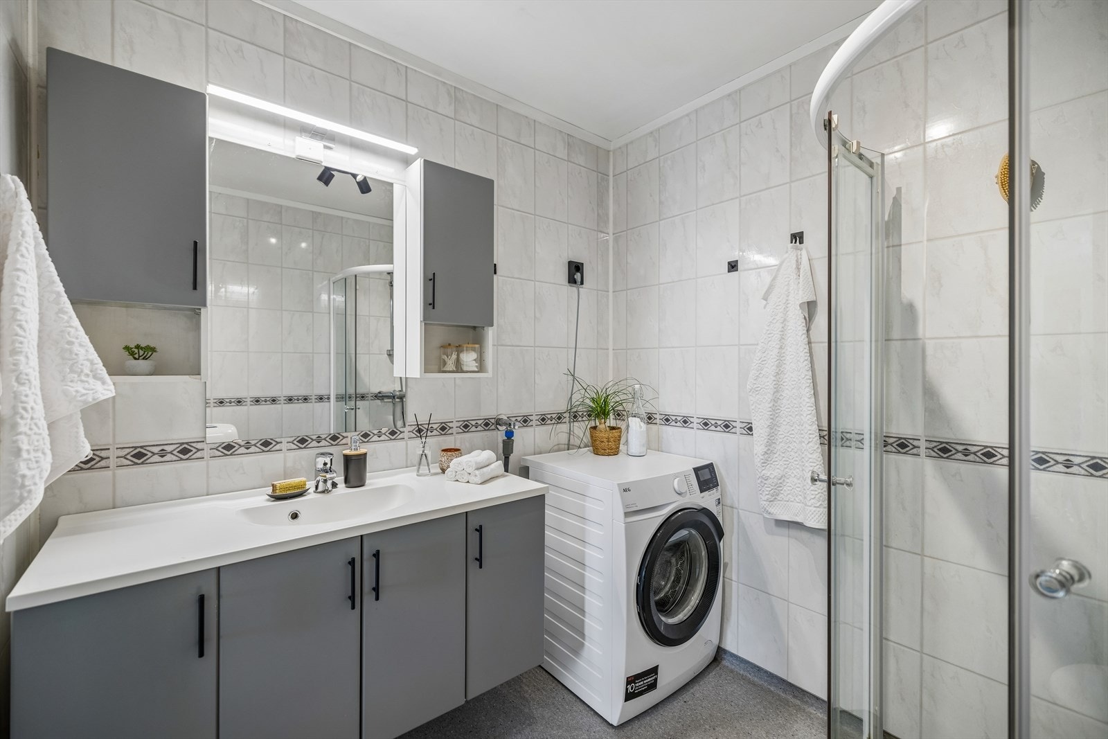 Badet har elektrisk gulvvarme, våtromsplater på veggene og opplegg for vaskemaskin. Galleribilde