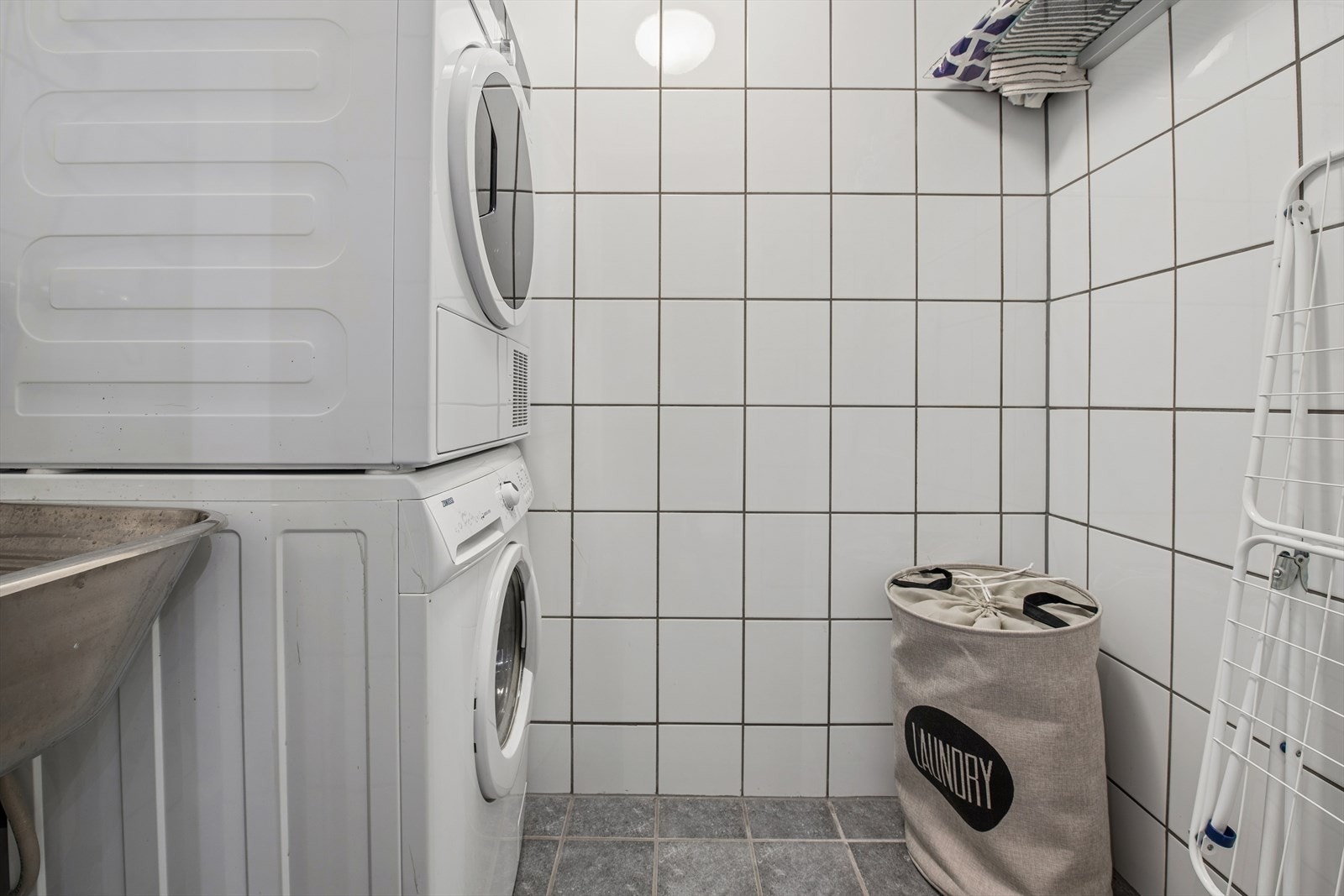 Rommet er utstyrt med opplegg for vaskemaskin og et skyllekar i stål. Galleribilde