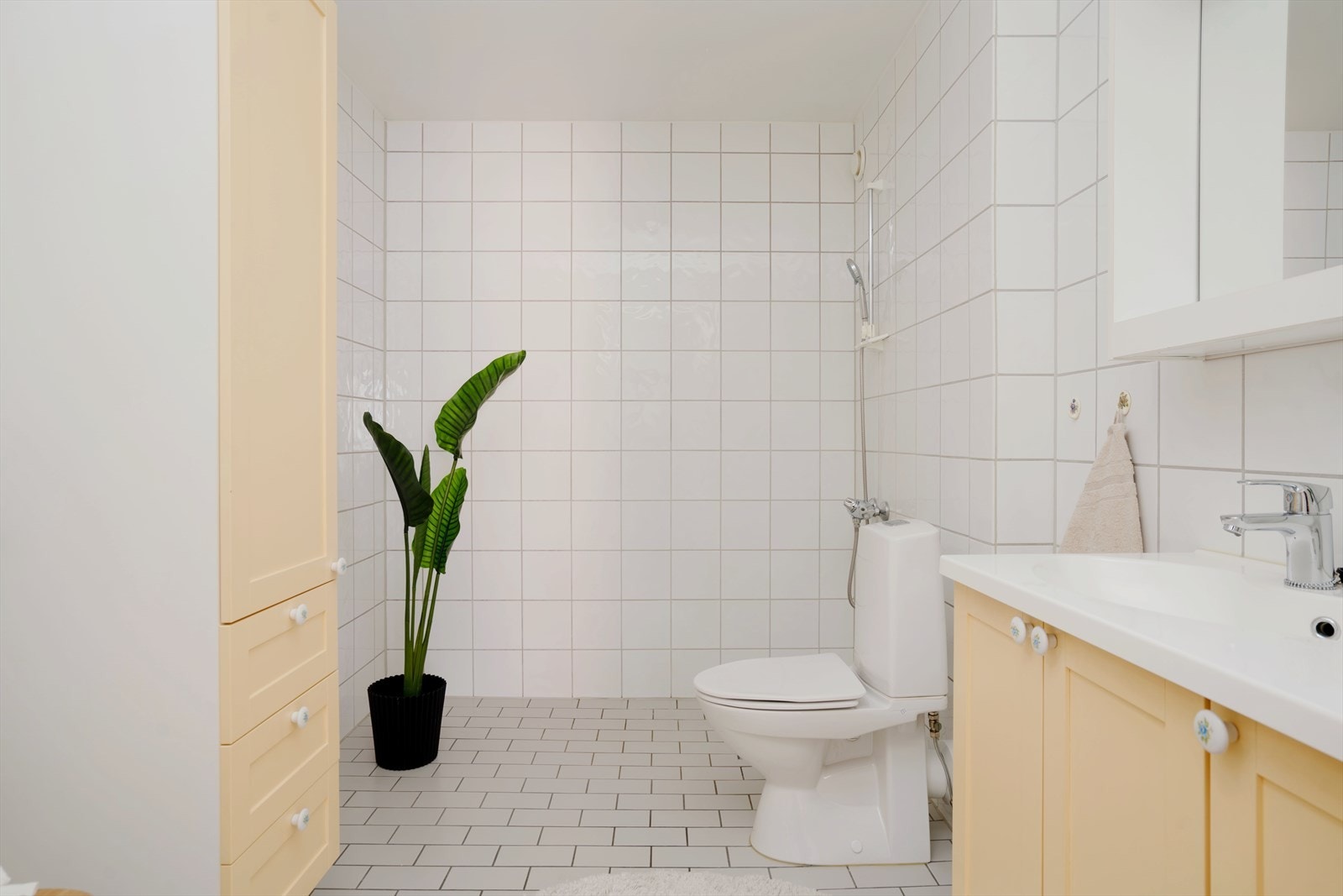 Badet er flislagt og utstyrt med dusjhjørne, servant med innredning og toalett, samt opplegg for vaskemaskin og tørketrommel. Galleribilde