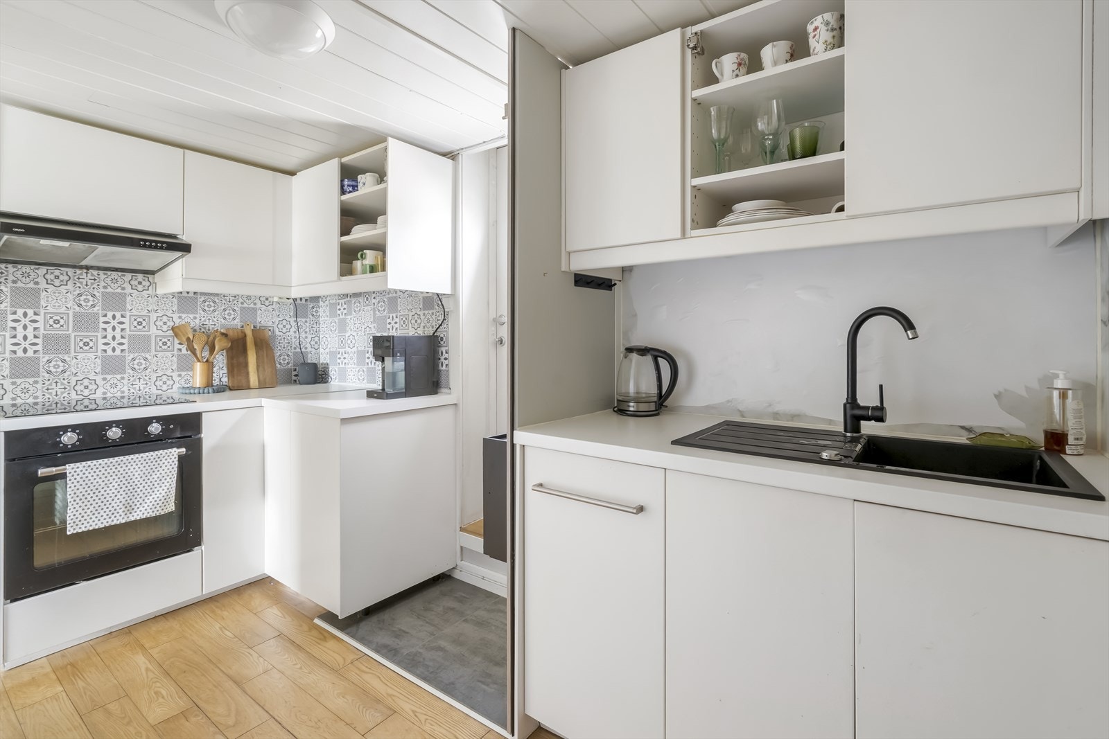 Kjøkkenet er et IKEA-kjøkken med hvite slette fronter, laminert benkeplate og oppvaskkum. Galleribilde