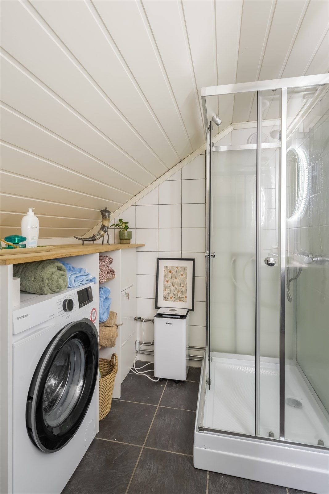 Badet er utstyrt med servantinnredning, dusjkabinett, opplegg for vaskemaskin og toalett. Galleribilde