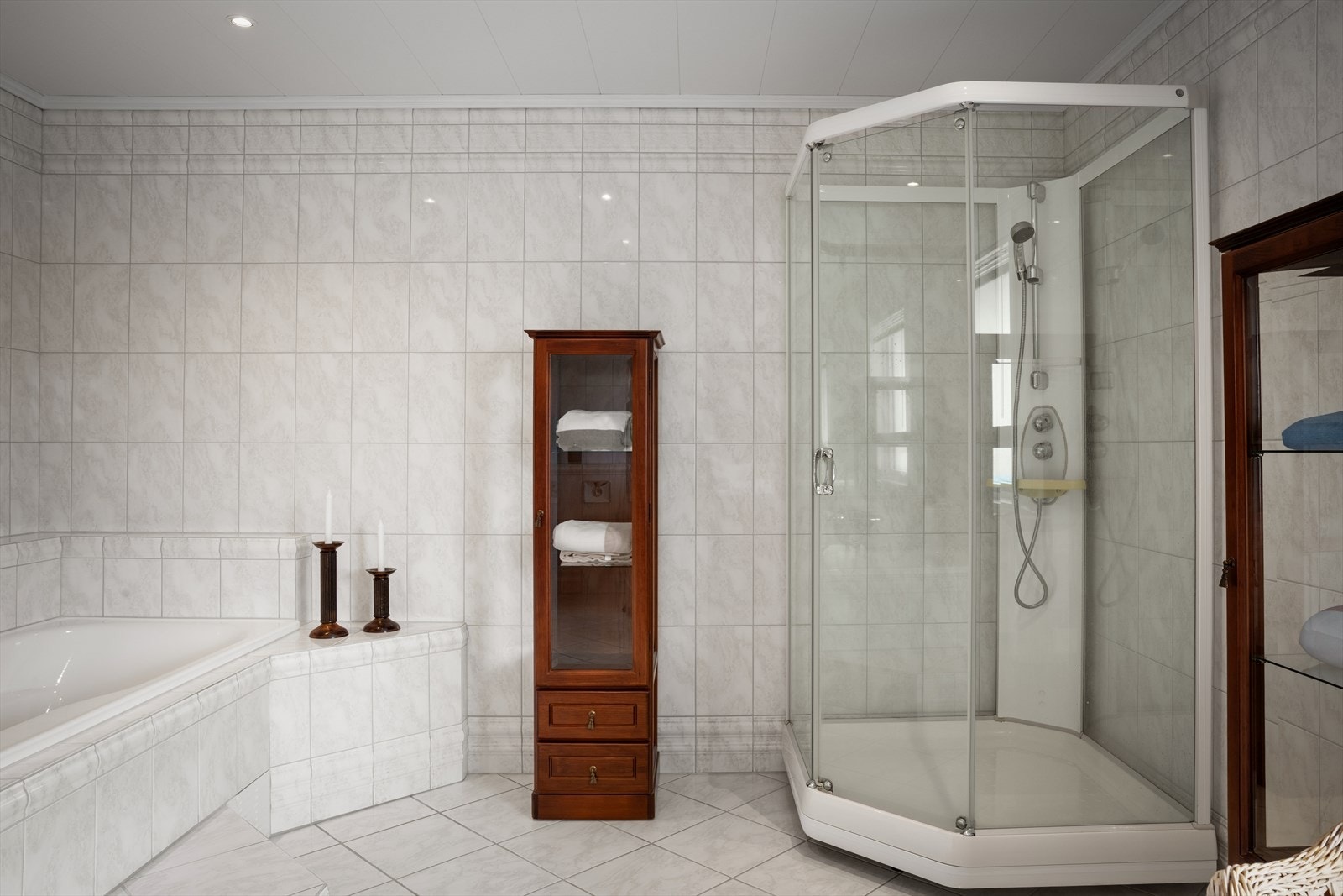 Badet er utstyrt med både dusjkabinett og et innbydende hjørnebadekar. Galleribilde