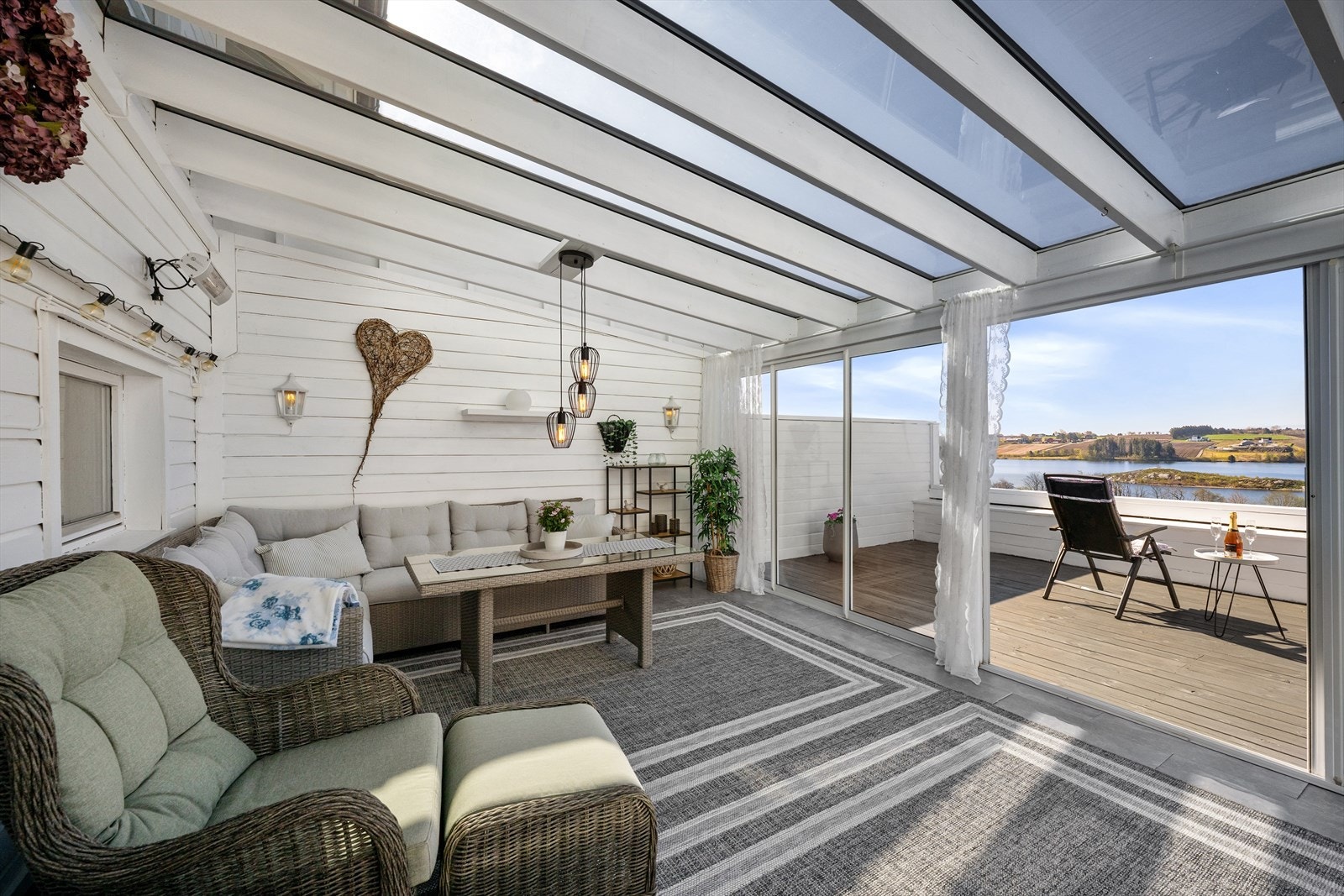 Store skyvedører i glass åpner opp mot terrassen og visker ut skillet mellom inne og ute. Galleribilde
