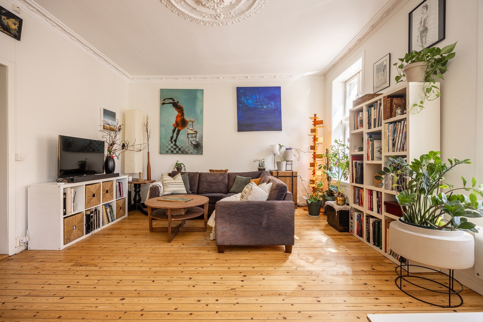 Stuen har flere møbleringssoner og en åpen forbindelse mot kjøkken og spiseplass Galleribilde