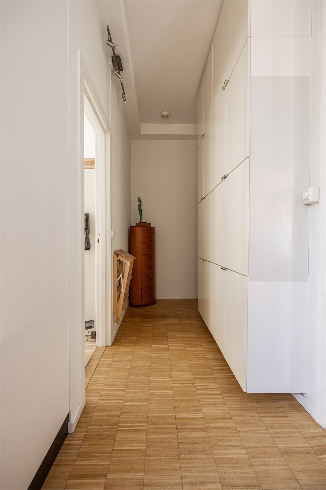 Entré/gang med tregulv og adkomst videre til boligens rom Galleribilde