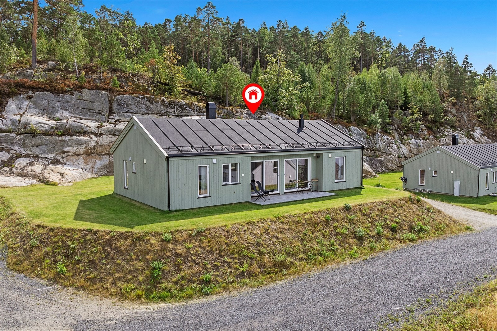 Tomten er opparbeidet med gruset adkomst og parkering, samt en terrasse på både nordvestsiden og sydøstsiden. Galleribilde
