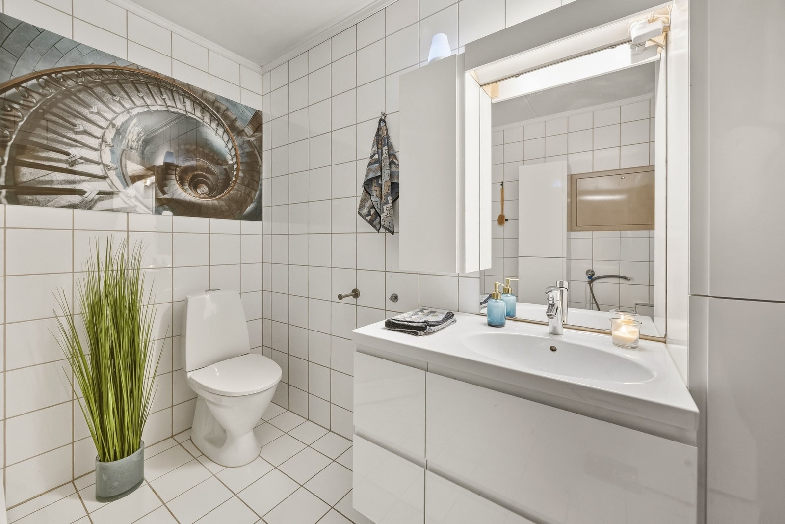 Badet er utstyrt med dusjkabinett med regnfallsdusj, servant med underskap, vegghengt skap og vannklosett. Galleribilde