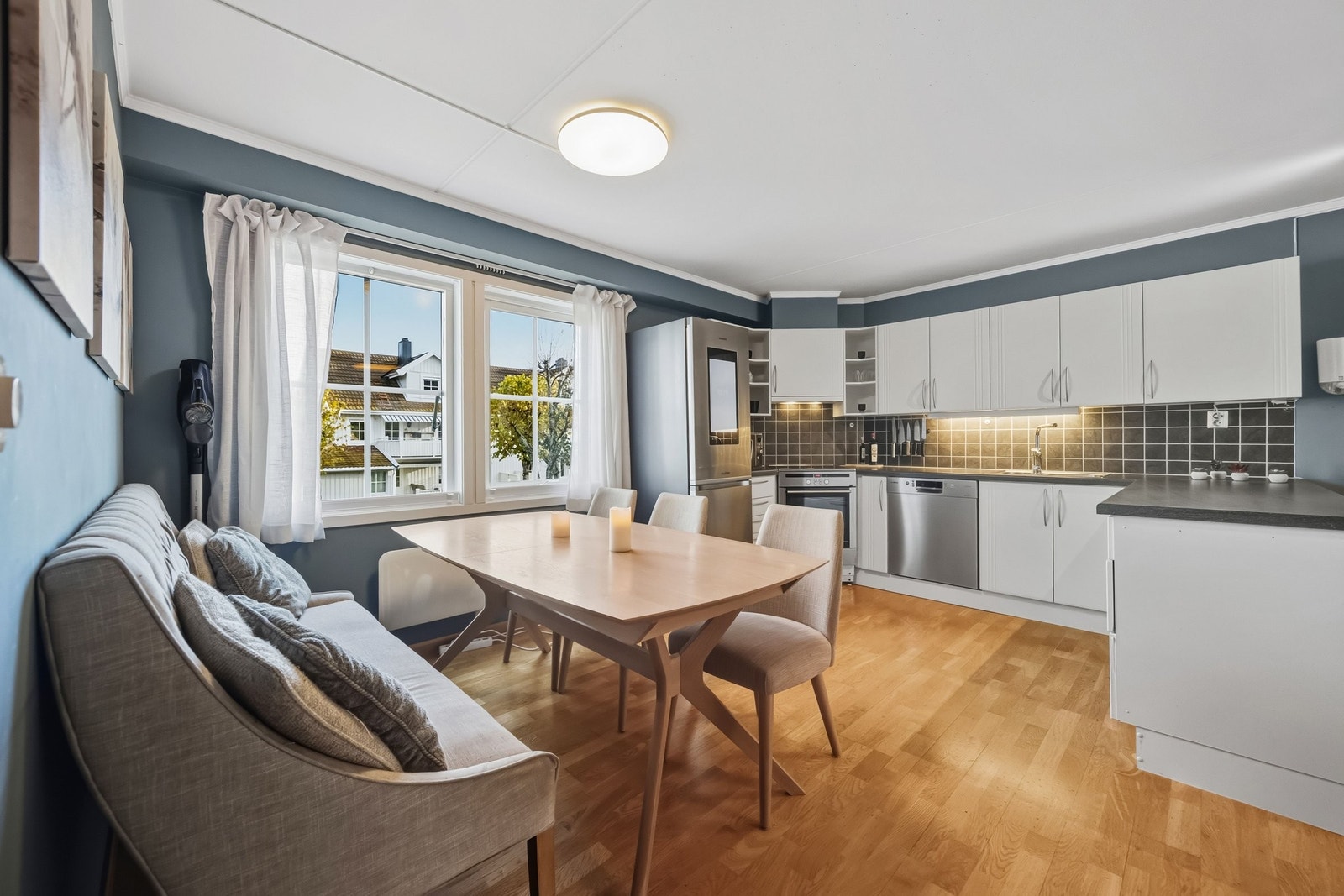 Kjøkkeninnredning har mye skapplass med undermontert belysning, lyse fronter og laminat benkeplate, som gir et tidløst og lettstelt inntrykk Galleribilde