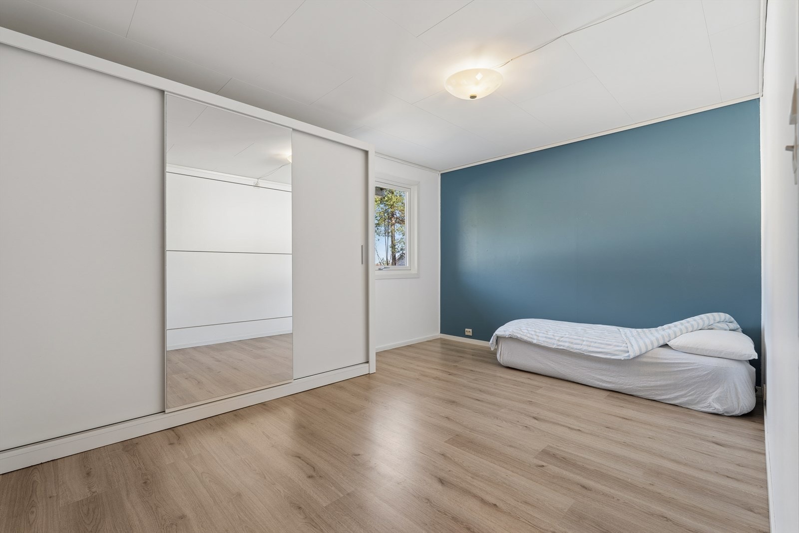 Et romslig soverom med god plass til dobbeltseng, nattbord og stor skyvedørsgarderobe med god oppbevaringsplass. Galleribilde
