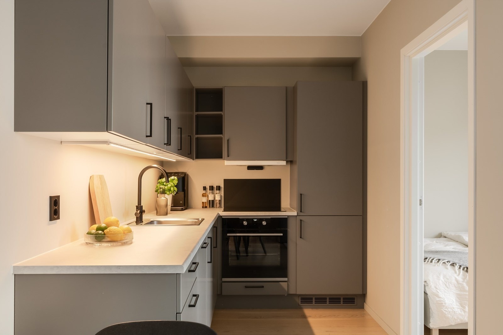 Et moderne kjøkken fra Huseby med behagelige og lune farger, her er det integrert kombiskap og oppvaskmaskin fra Electrolux! Galleribilde