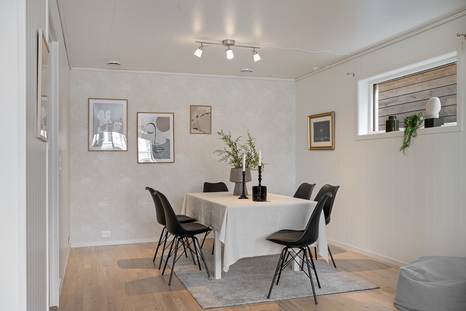 Stuen har lys eikeparkett på gulv og malte plater på vegg med unntak av kontrastvegg som er tapetsert. Galleribilde