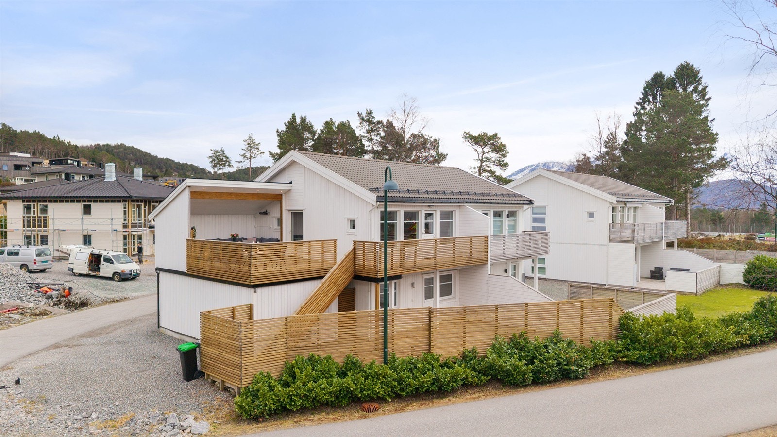 En utvendig trapp i tre forbinder den øvre verandaen med terrassen på bakkeplan. Galleribilde