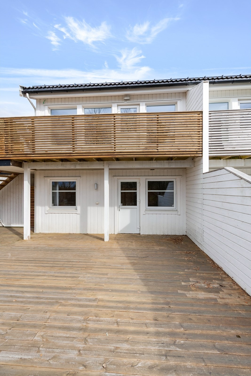 Den vestvendte terrassen på 53 m² har direkte adkomst fra ett av soverommene i første etasje og fra svalgang mellom hus og carport. Galleribilde