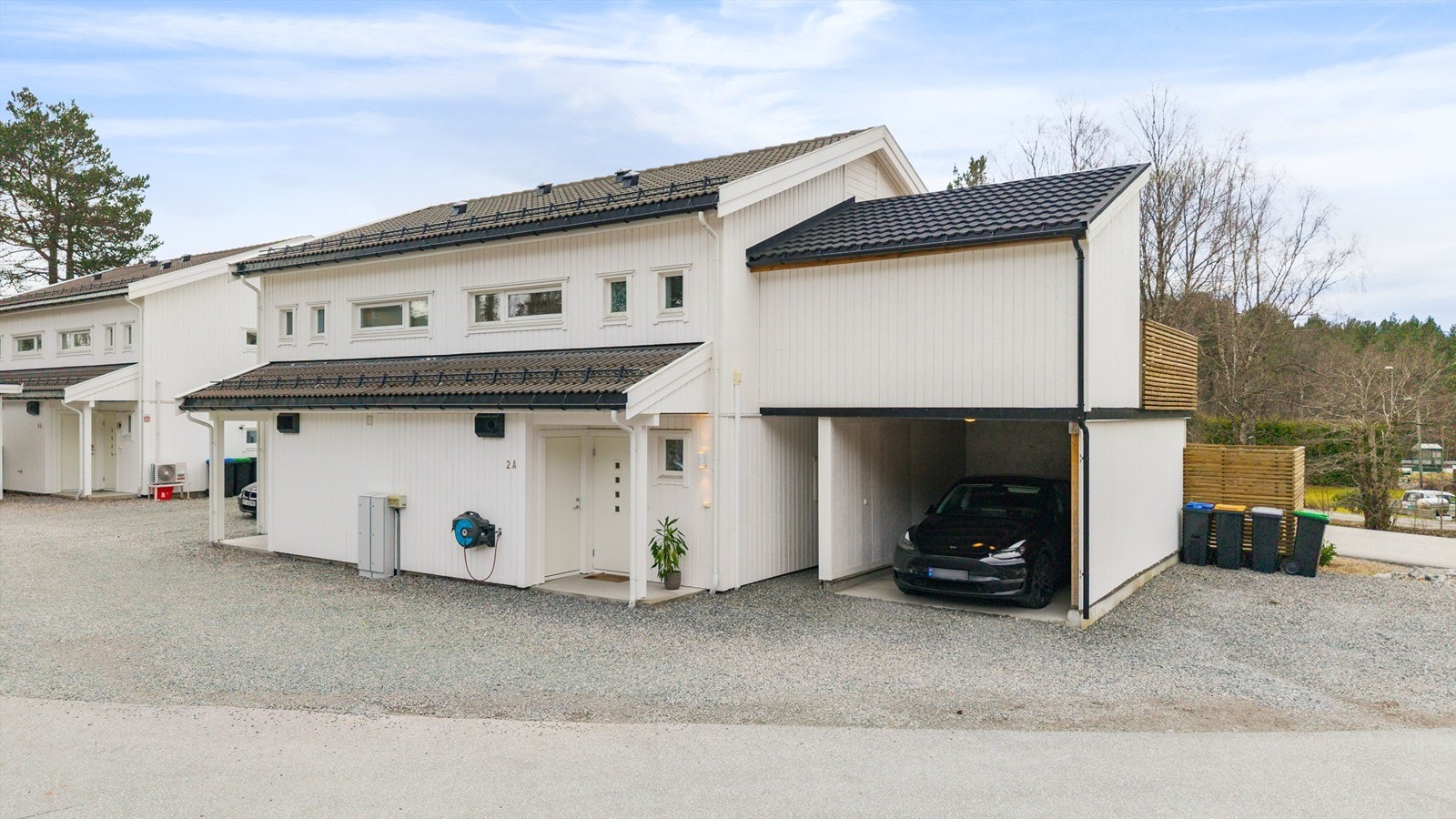 Praktisk carport med elbillader og en ekstern bod på 5 m² gir en enkel hverdag. Herfra er det gangavstand til skoler, butikker og idrettsanlegg. Foto: Stian Wiik Galleribilde