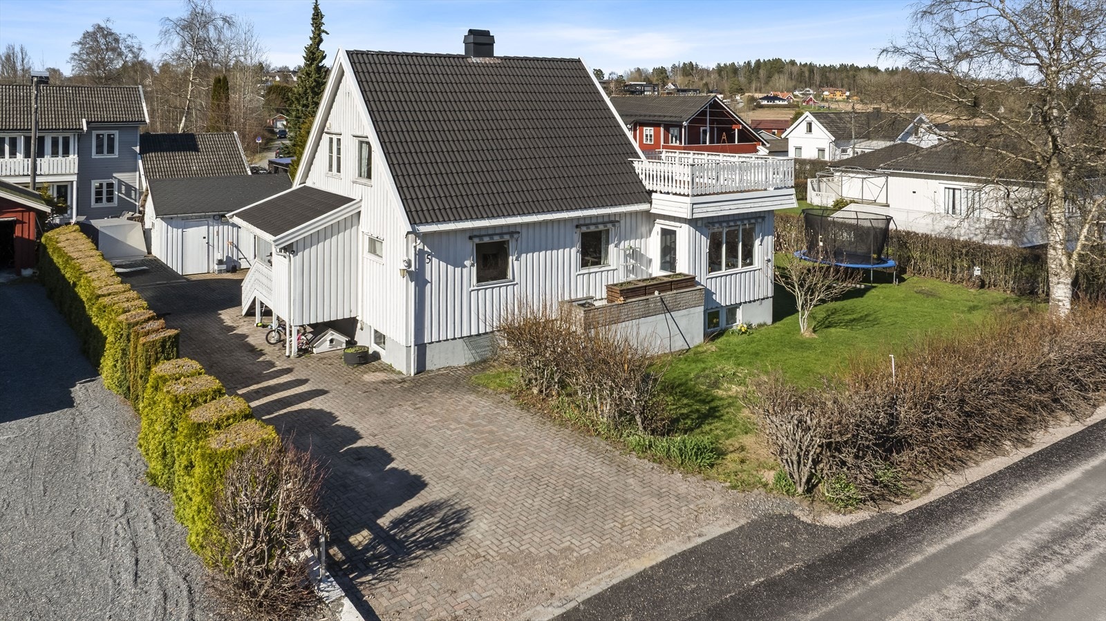 Steinbelagt innkjørsel som gir et ryddig og praktisk uteområde med gode parkeringsmuligheter Galleribilde