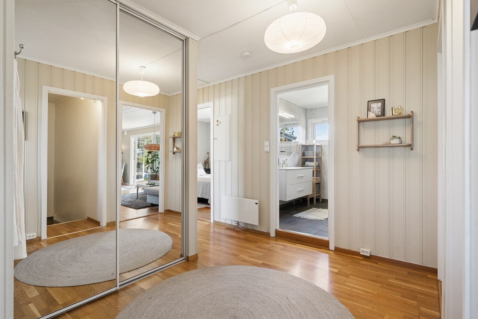 Entreen fungerer som et naturlig knutepunkt i etasjen og fordeler adkomsten til rommene i første etasje. Herfra går også trappen ned til kjelleren. Galleribilde