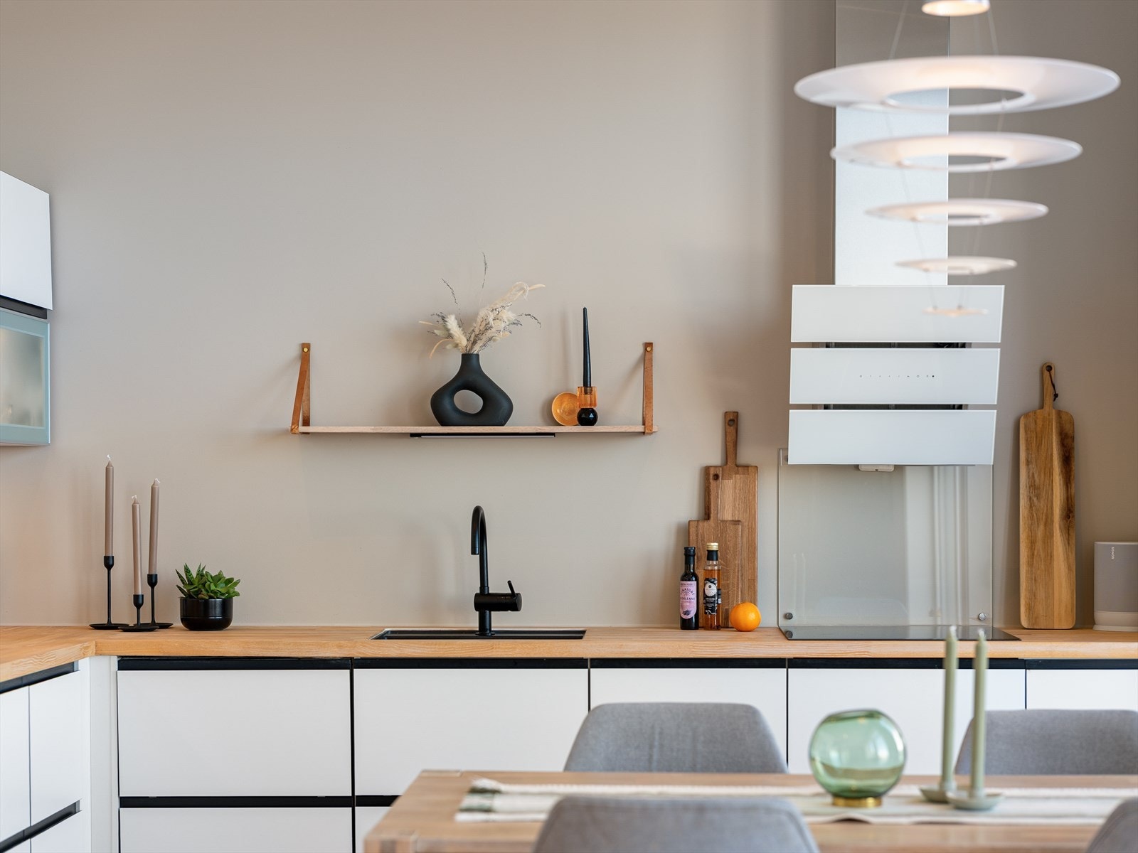 Moderne detaljer som sort armatur og praktisk, åpen hylleløsning. Galleribilde