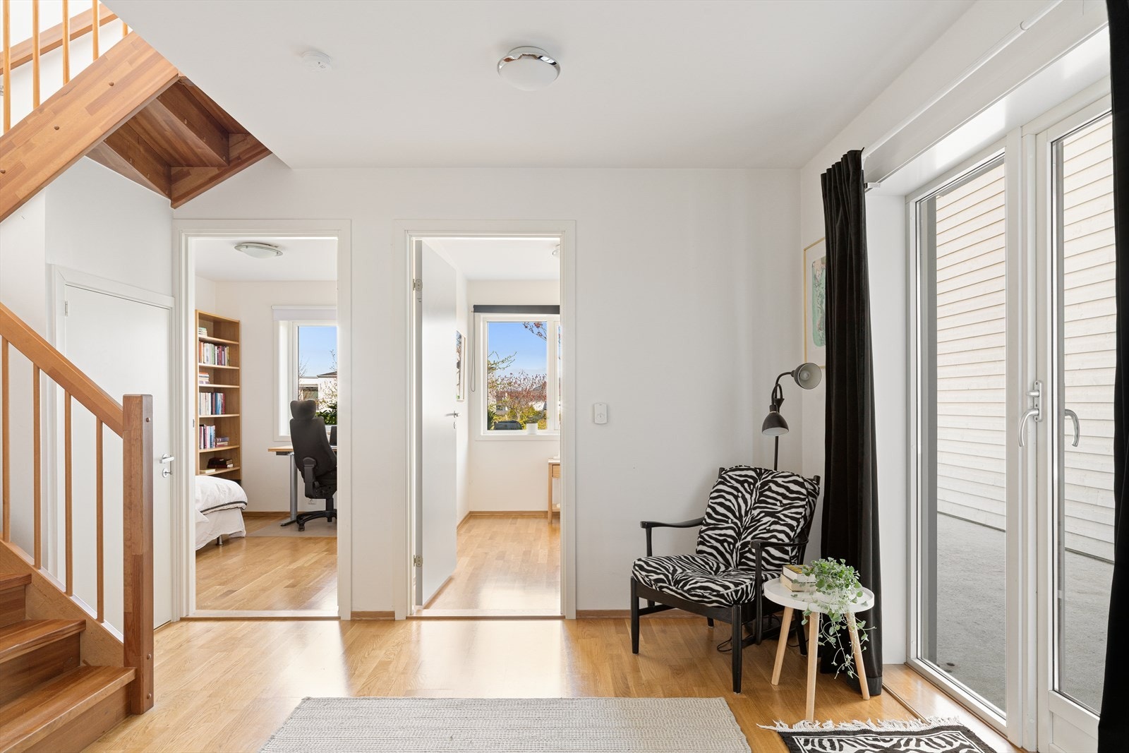 Boligens første etasje byr på en praktisk planløsning med tre soverom, hall med gulvvarme, lagringsplass under trapp, bod, utgang til terrasse, samt bad med opplegg for vaskemaskin. Galleribilde