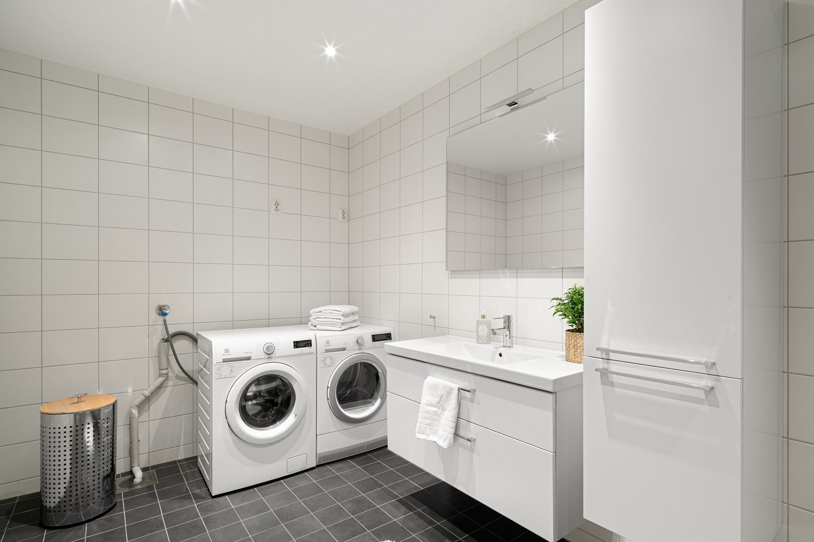 Det delikate badet fremstår moderne og helfliset i tidsriktige fargetoner, og er utstyrt med gulvvarme, servant med god oppbevaringsplass, skap, toalett og dusjhjørne med innfellbare vegger. Galleribilde