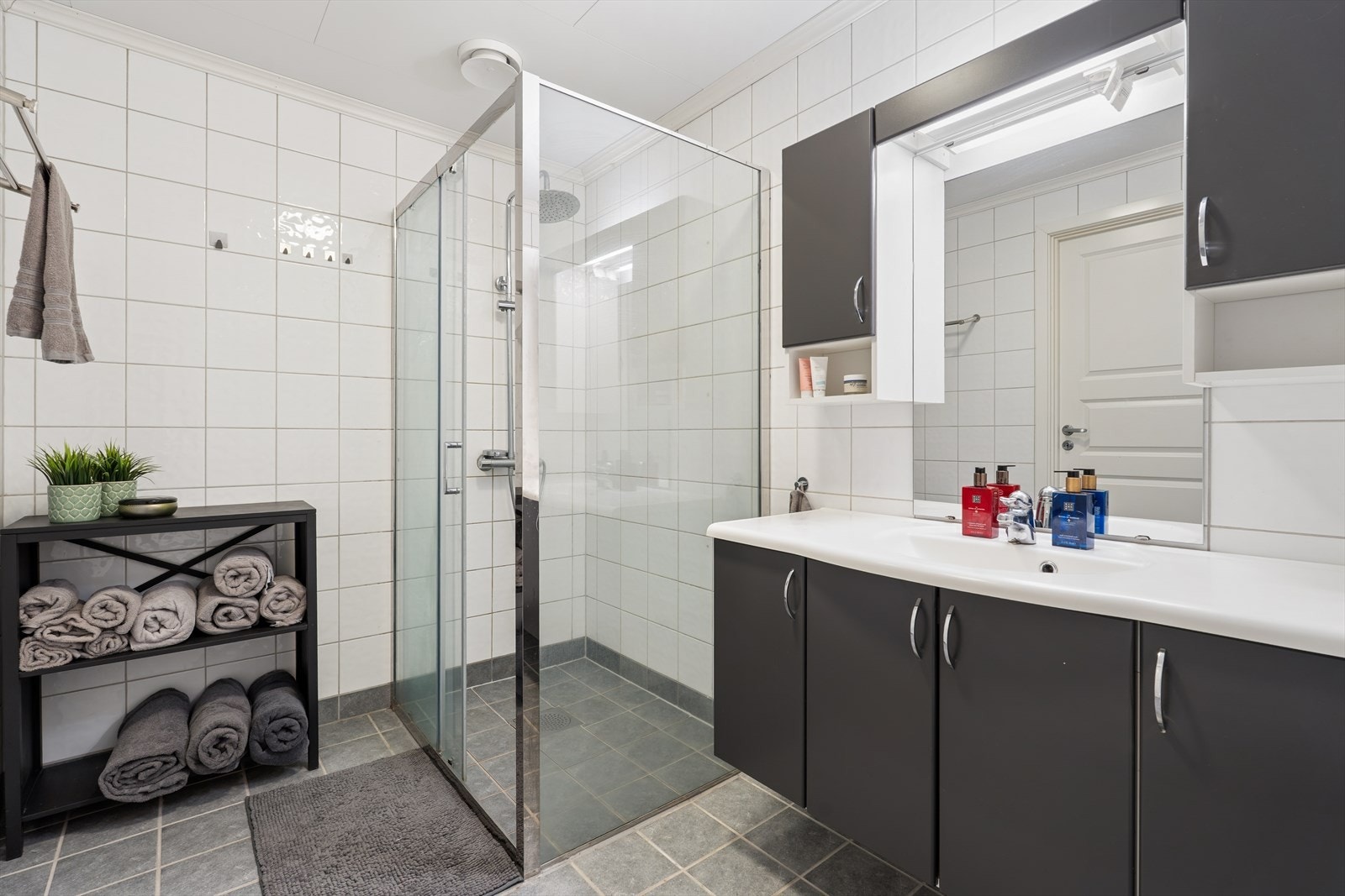 Badet fremstår som flott og moderne med flislagte overflater og tidløse materialvalg som gir et helhetlig og innbydende uttrykk. Galleribilde