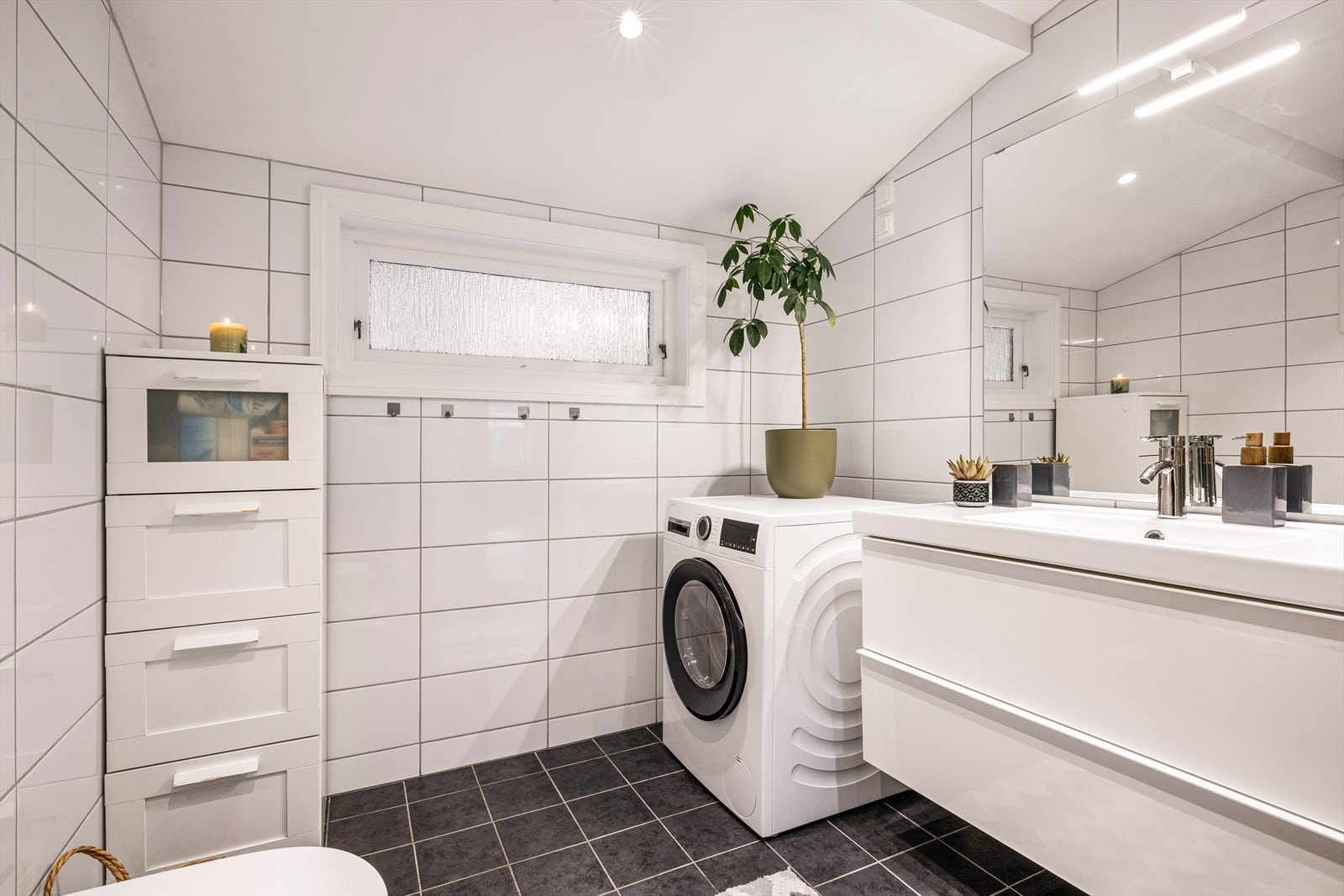 Badet er praktisk innredet med plass til både vaskemaskin og ekstra oppbevaring. Galleribilde