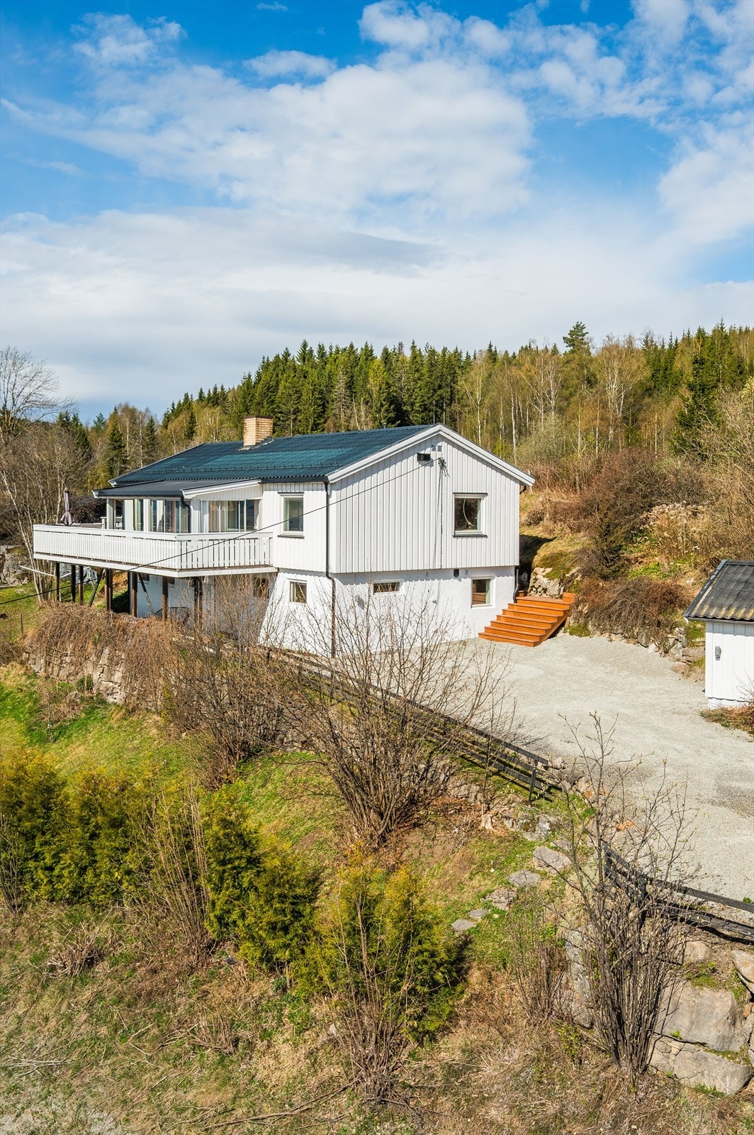Tomten er er flat/skrånende og opparbeidet med plen og beplantning. Gruset gårdsplass. Galleribilde
