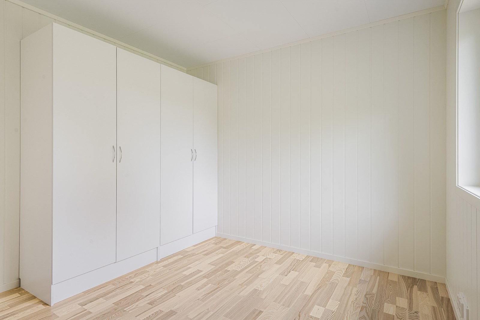 Soverommet har parkett på gulv, lyse panelplater på veggene og god oppbevaringsplass i medfølgende garderobeskap. Galleribilde