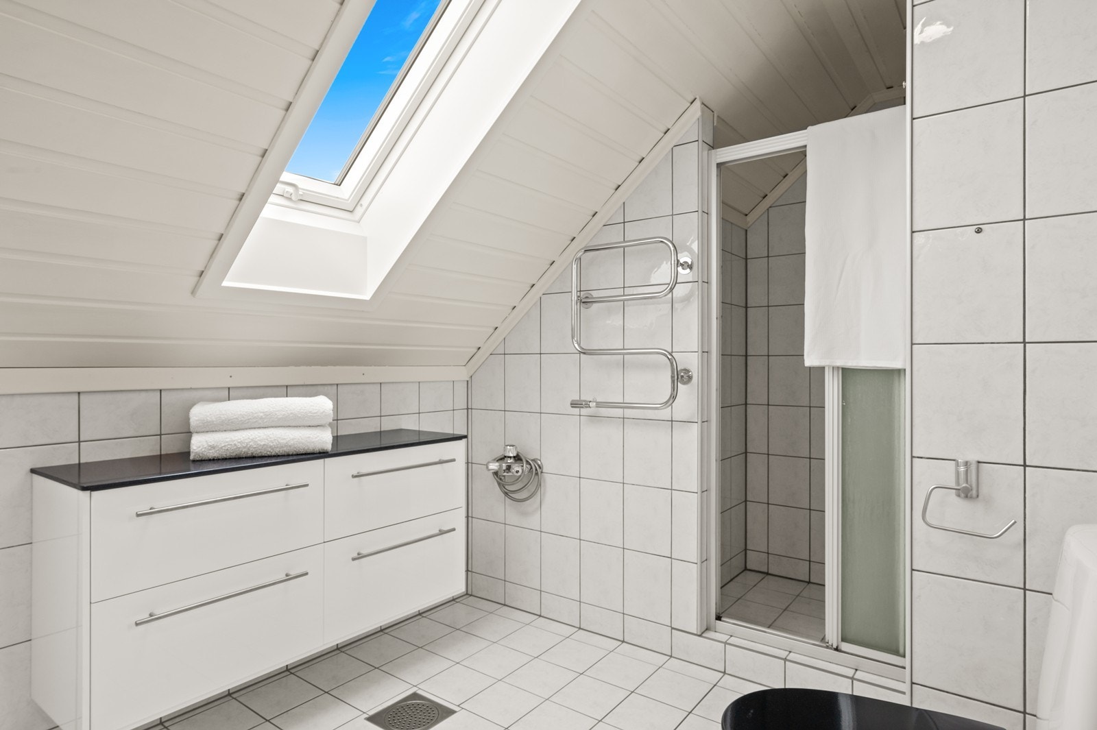 Badet har også en praktisk dusjnisje og takvindu som gir godt med naturlig lys. Galleribilde