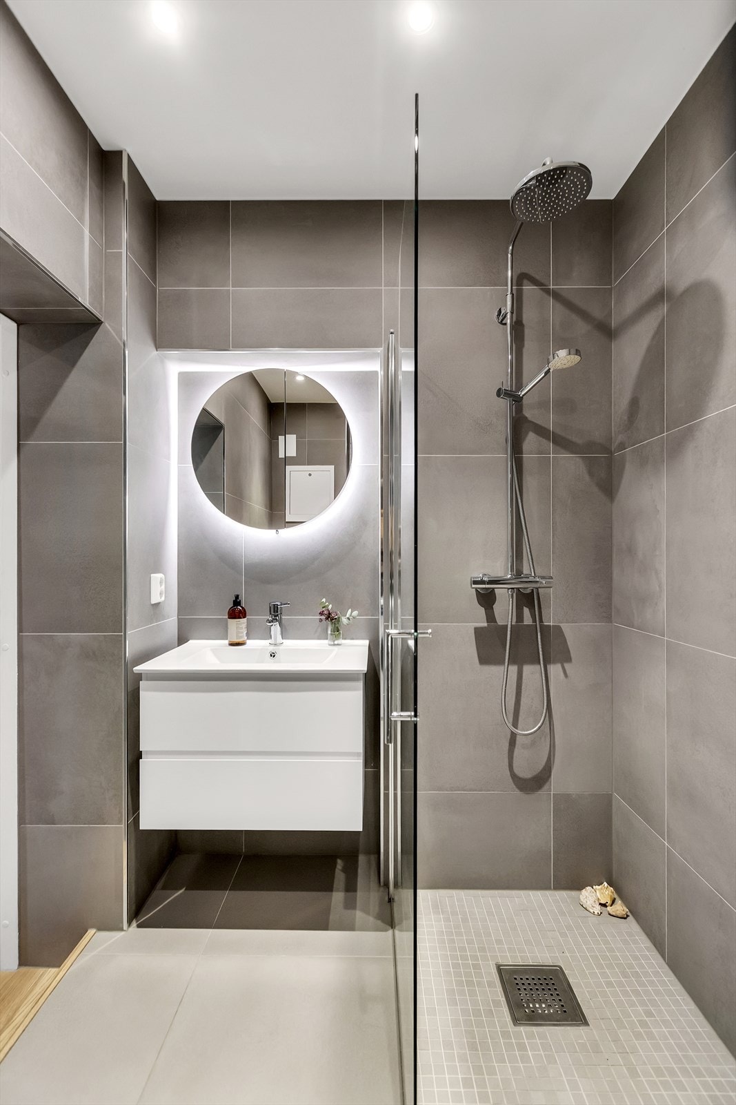 Badet har flislagte overflater, elektrisk gulvvarme og downlights i himling. Det er opplegg for vaskemaskin. Galleribilde