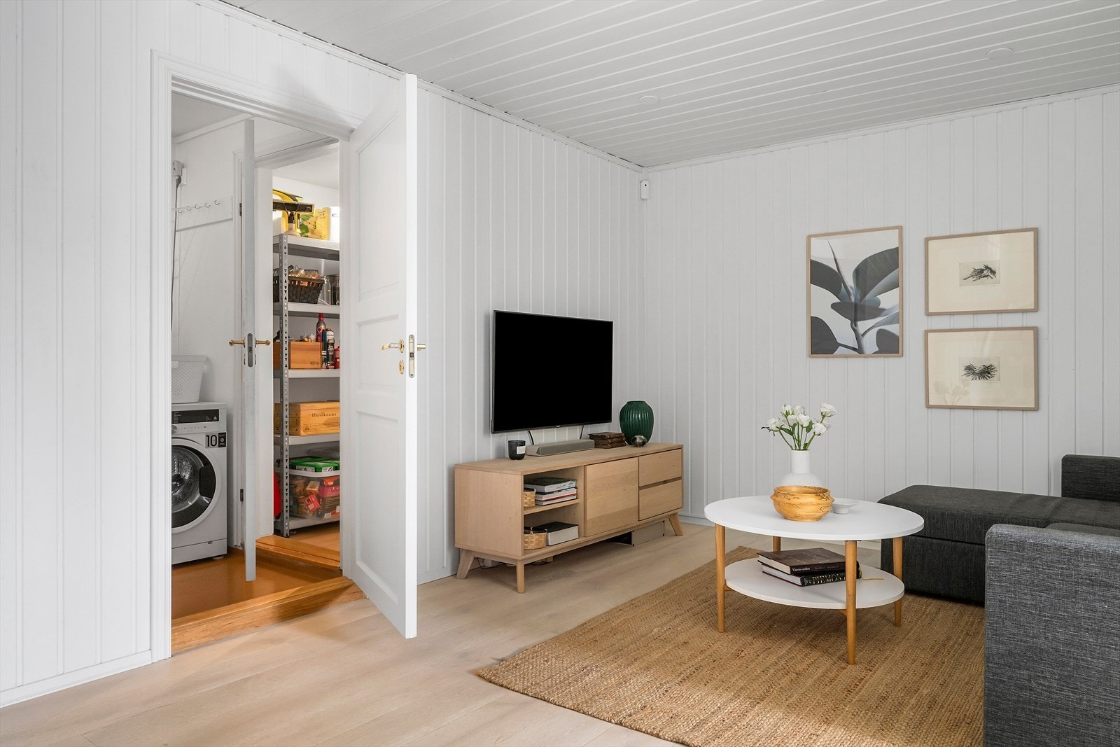 Fra oppholdsrommet er inngang til vaskerom og videre til en liten bod. Galleribilde
