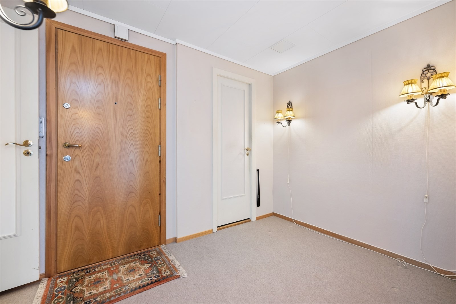 Fra det felles trapperommet kommer en inn i leilighetens romslige gang. Galleribilde