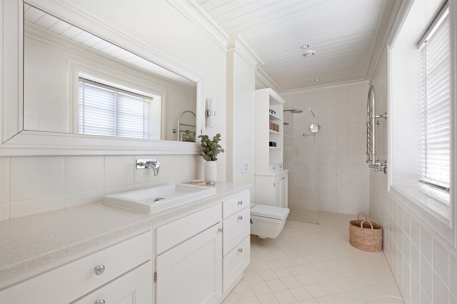 Badet er utstyrt med vannbåren gulvvarme, vegghengt toalett og et dusjhjørne med glassvegg Galleribilde