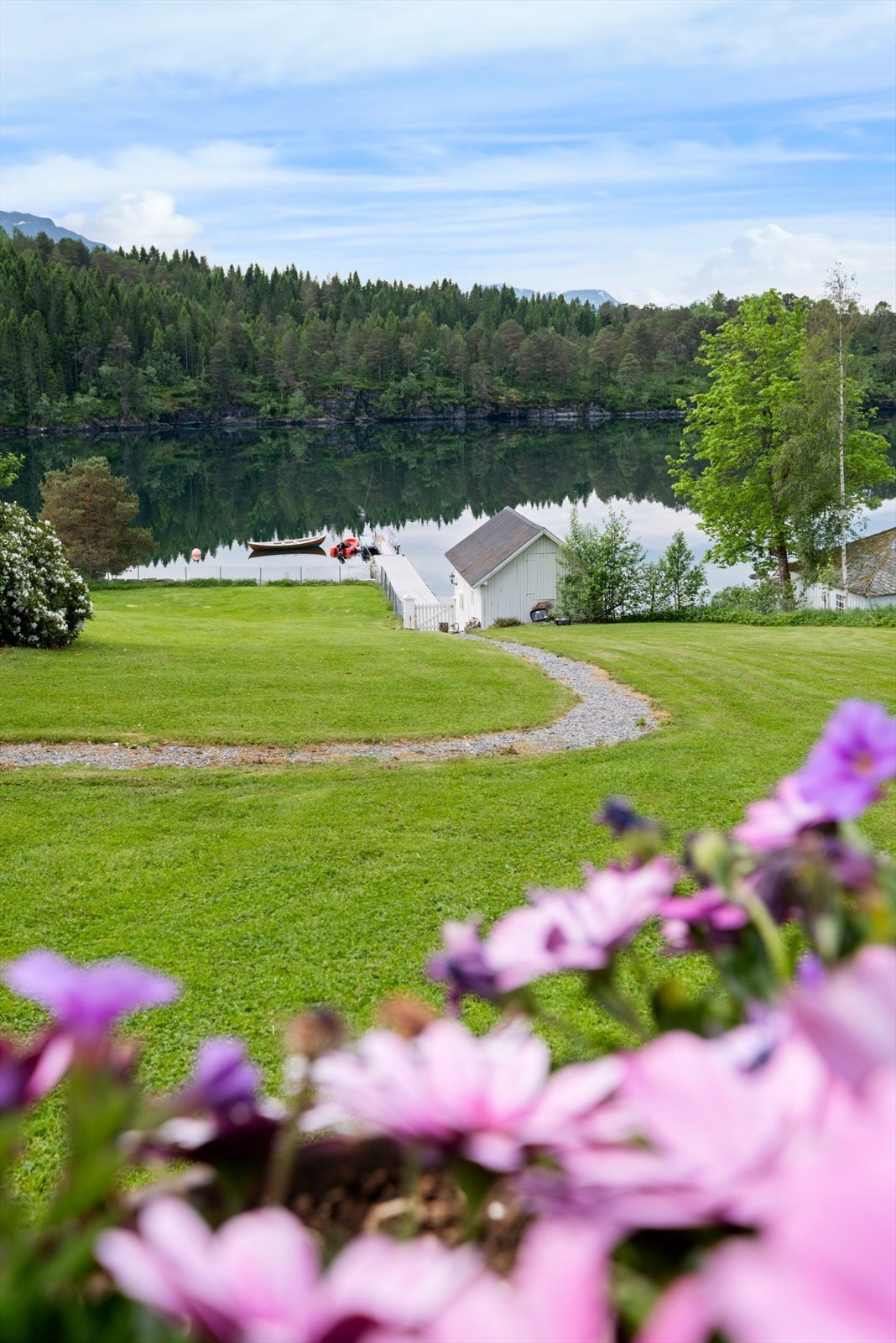 En sjarmerende sti slynger seg gjennom hagen ned mot naustet og bryggen Galleribilde