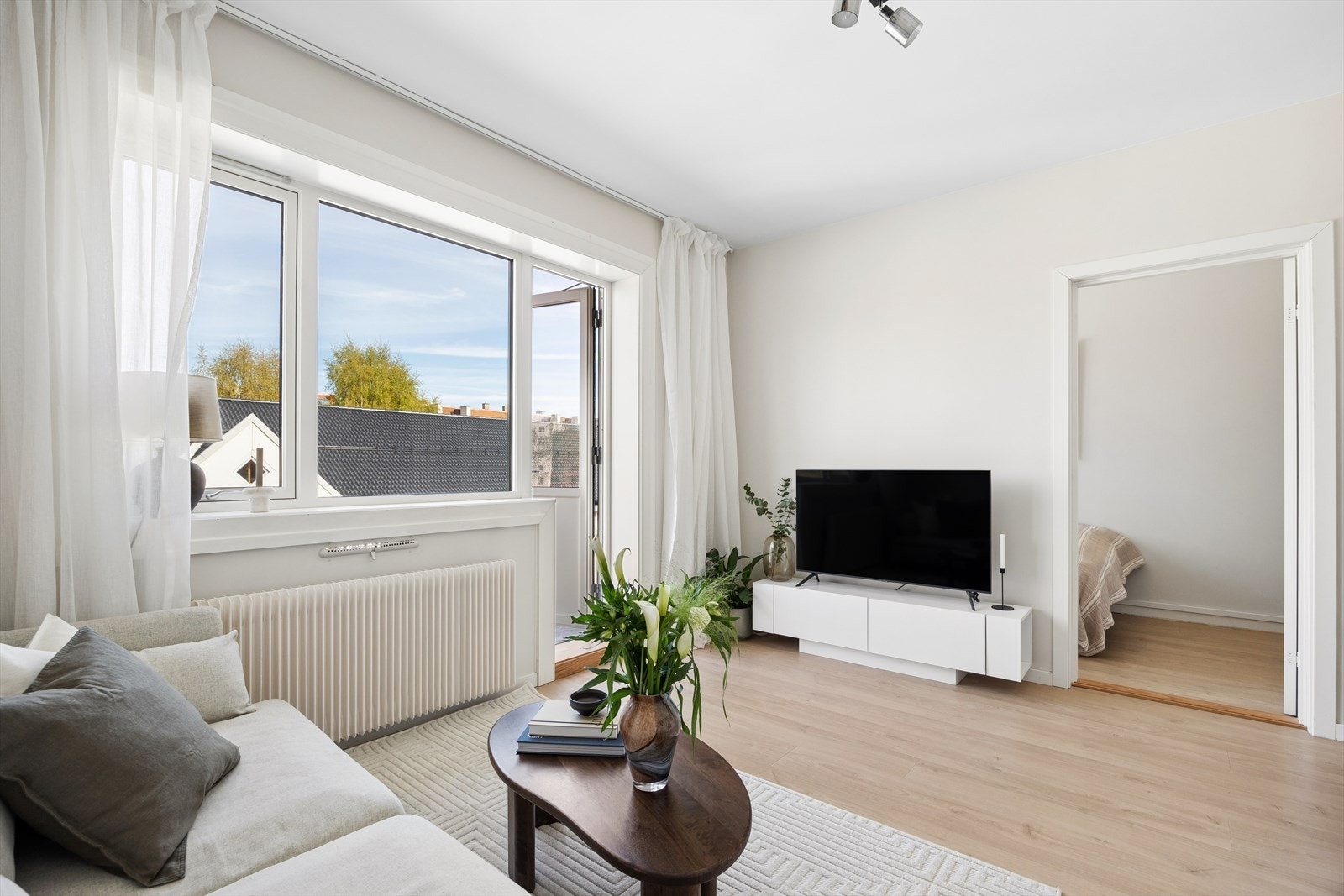 Lys og sosial stue-/kjøkkenløsning som enkelt lar seg møblere med sofa og TV-løsning. Galleribilde