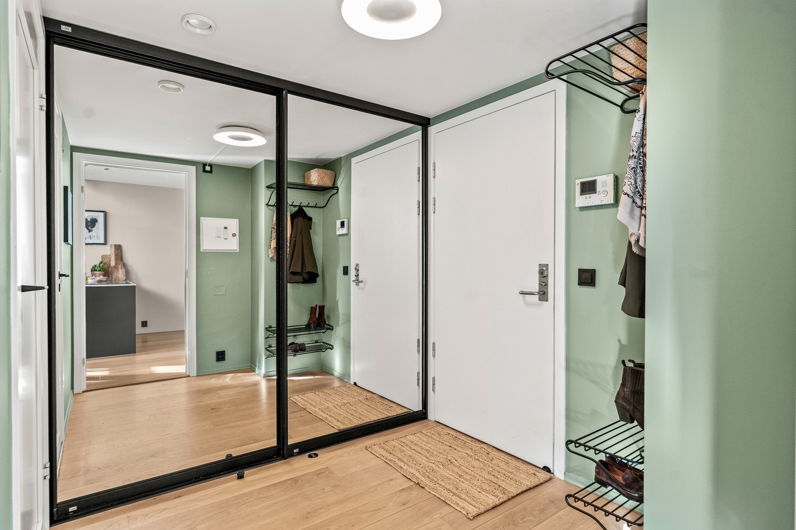 Innbydende entré av god størrelse med stor og dyp skyvedørsgarderobe med speilfronter. Vegghengte knagger for yttertøy samt hattehylle og skohyller. Dørcalling-anlegg med kamera. Galleribilde