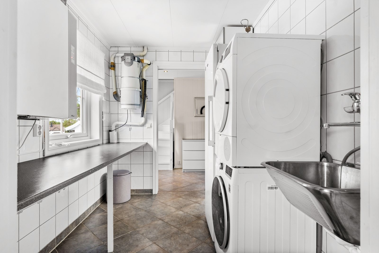 Vegg i vegg med badet ligger et flislagt vaskerom. Galleribilde
