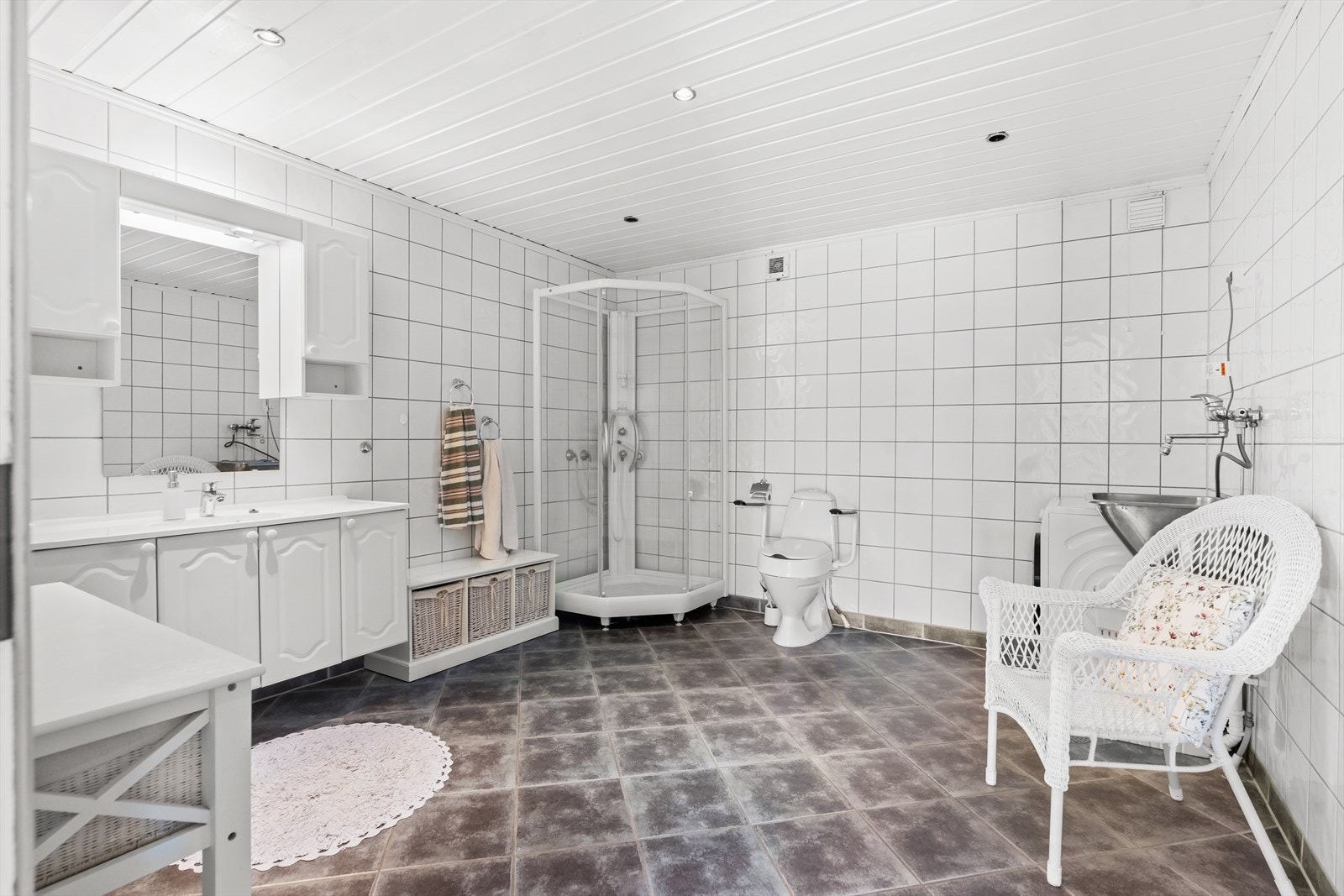 Etasjens bad har toalett, innredning med nedfelt servant, dusjkabinett og opplegg for vaskemaskin. Galleribilde