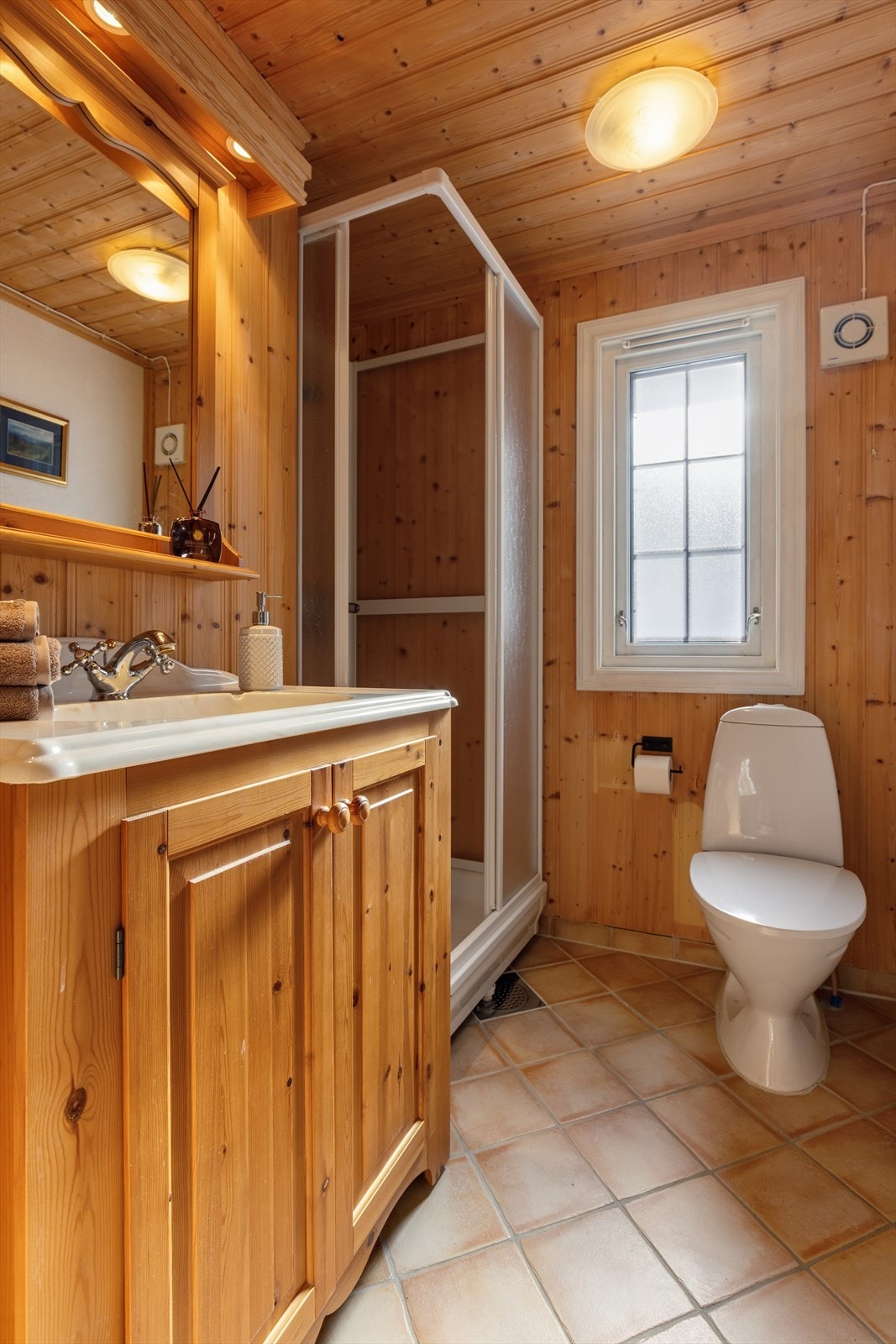 Badet har vegger med panel og flislagt gulv med elektrisk gulvvarme. Galleribilde
