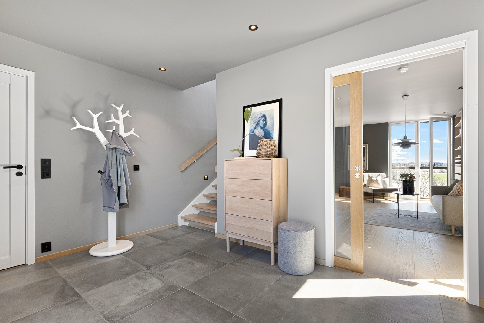 Fra entréen leder en skyvedør i glass inn til TV-stuen, og den åpne trappen med eiketrinn forbinder etasjene. Galleribilde