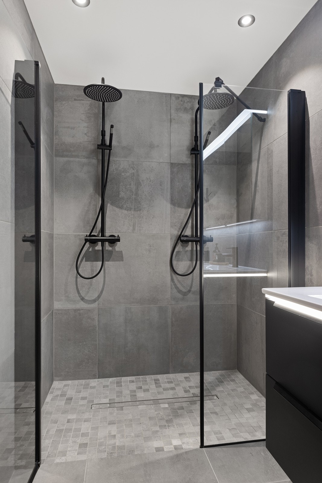 Dusjsonen er utstyrt med dobbel dusj med nye armaturer og slukrenne i gulvet. Det er gulvvarme på hele badet. Galleribilde