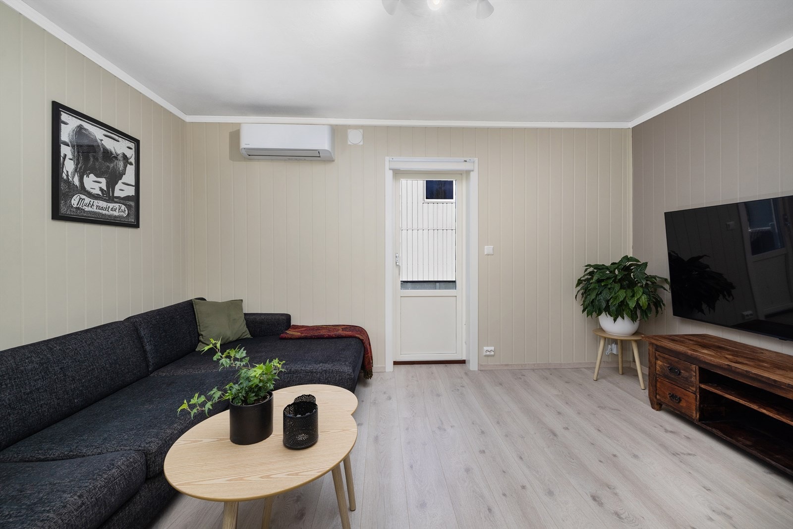 Veggflatene i stuen er kledd med panelplater, og rommet er enkelt å møblere med plass til en romslig sofagruppe. Galleribilde