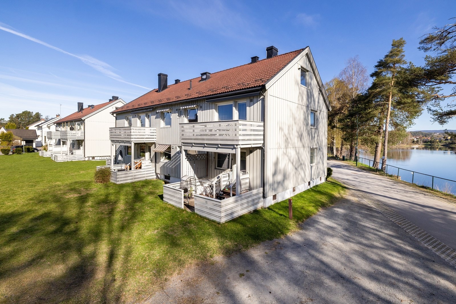 Eiendommen har en eiet, flat tomt som er opparbeidet med plen, og balkongene vender ut mot grønne omgivelser. Galleribilde