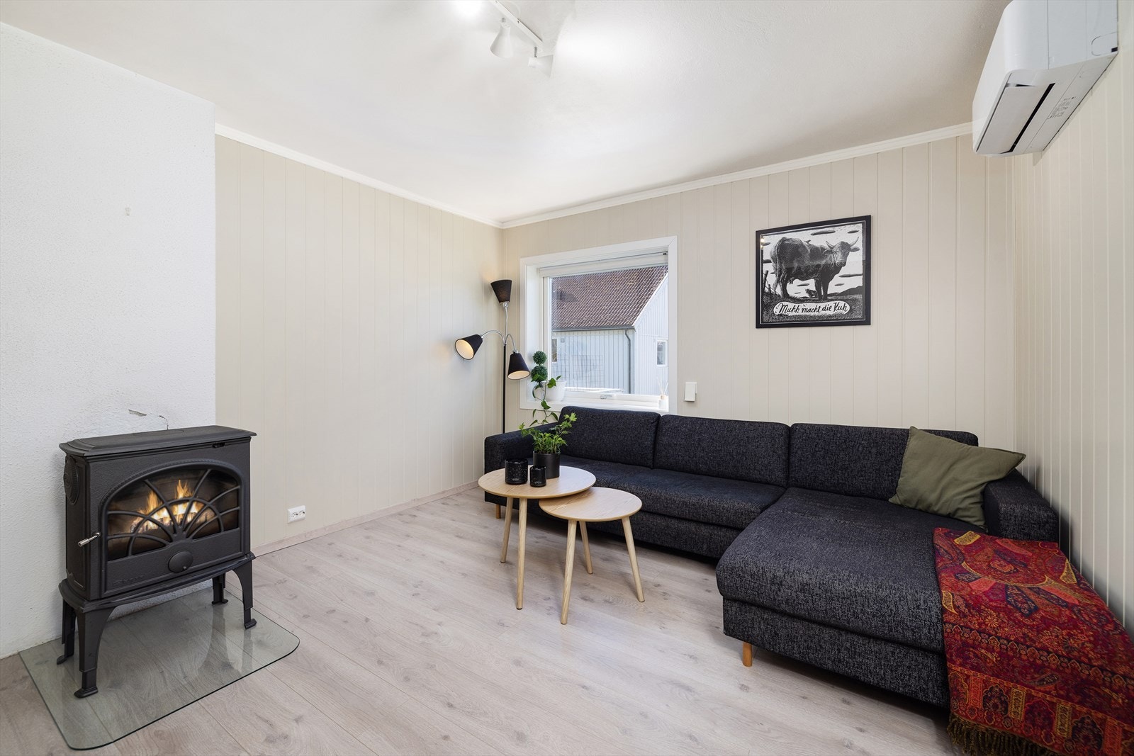 Store vinduer gir rikelig med naturlig lys, og bidrar til en lys og åpen atmosfære i stuen. Galleribilde
